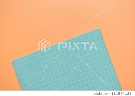 green cutting mat on orange background, object tool for design green cutting mat on orange background, object tool for design 111974122