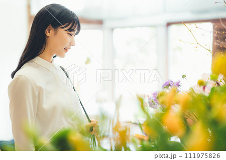 花屋にお花を買いに来た女性 111975826