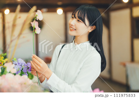 花屋にお花を買いに来た女性 111975833