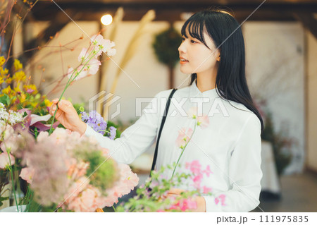 花屋にお花を買いに来た女性 111975835