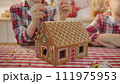 Cute boys decorating gingerbread house with topping and icing at the kitchen 111975953