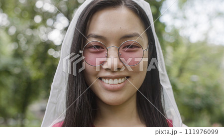 Happy asian woman in pink sunglasses smiling on camera, carefree woman portrait 111976099