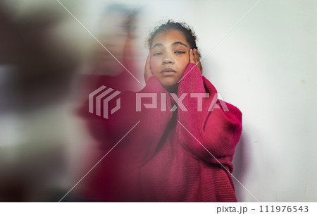 Portrait of anxious woman holding her head in hands, looking at camera. 111976543