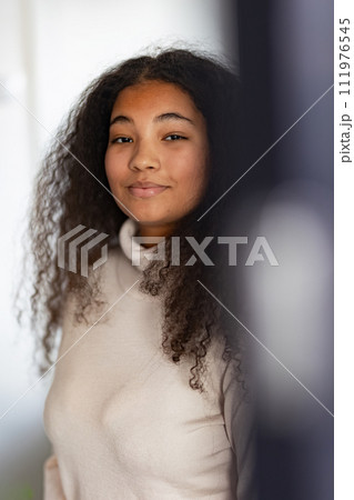 Portrait of beautiful curvy woman with beautiful curly hair, looking at camera. 111976545