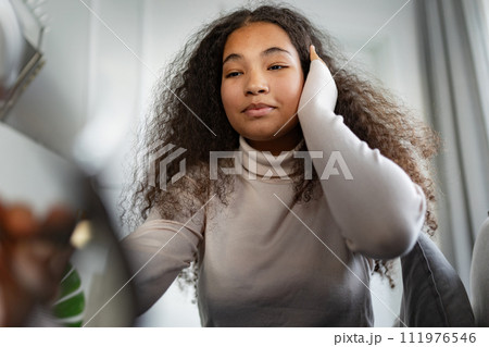 Portrait of beautiful curvy woman with beautiful curly hair, looking at camera. 111976546