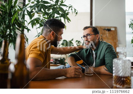 Best friends, supporting each other, drinking whiskey and talking. Discussing problems and drowning sorrows in alcohol. Concept of male friendship, bromance. Best friends, supporting each other, drinking whiskey and talking. Discussing problems and drowning sorrows in alcohol. Concept of male friendship, bromance. 111976662