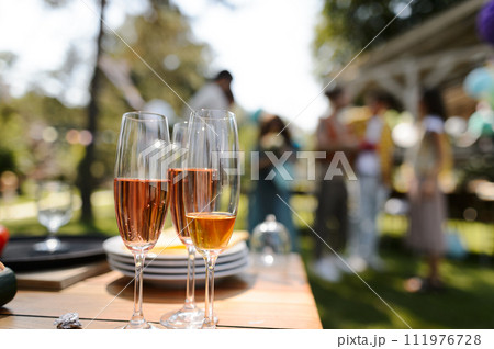 Close up shot of wine in glassed at summer garden party. Close up shot of wine in glassed at summer garden party. 111976728