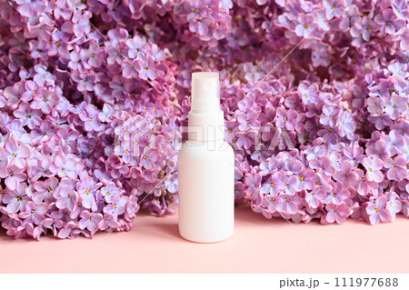 cosmetic spray bottle and lilac flowers. Antibacterial liquid, natural organic oil, body mist, sanitizer, perfume, sunscreen, deodorant. skincare product blank package, cosmetology product mockup cosmetic spray bottle and lilac flowers. Antibacterial liquid, natural organic oil, body mist, sanitizer, perfume, sunscreen, deodorant. skincare product blank package, cosmetology product mockup 111977688