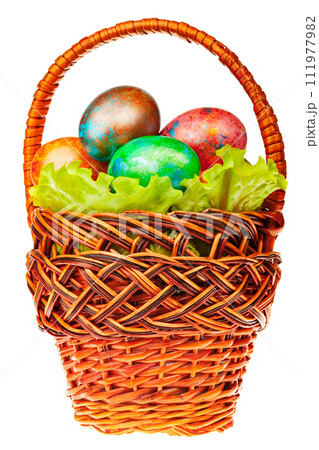 Vibrant Hand-Painted Easter Eggs in Wicker Basket Isolated Vibrant Hand-Painted Easter Eggs in Wicker Basket Isolated 111977982