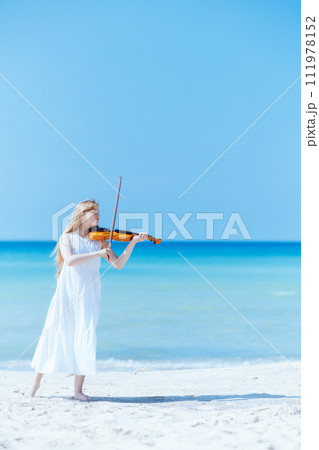 teenager girl in dress on ocean shore enjoying playing 111978152