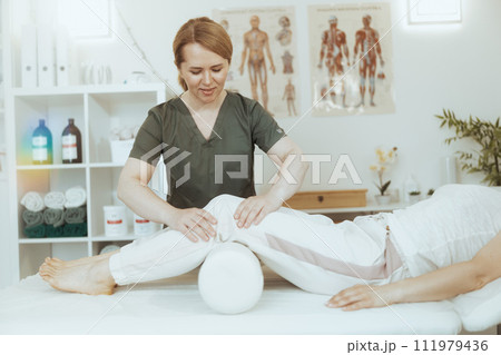 smiling therapist woman in massage cabinet doing checkup 111979436