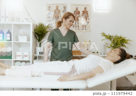 smiling therapist woman in massage cabinet doing checkup 111979442