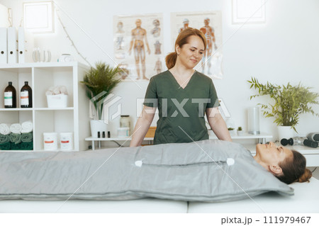 smiling female medical massage therapist in massage cabinet 111979467