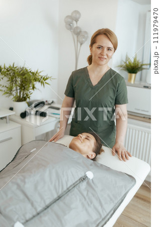 happy female medical massage therapist in massage cabinet 111979470