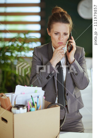 stressed woman worker in green office talking on phone stressed woman worker in green office talking on phone 111979857