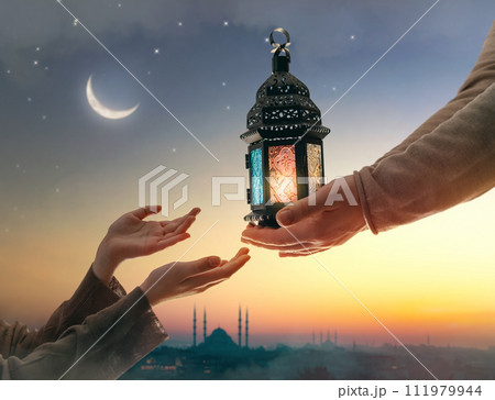 Ornamental Arabic lantern with burning candle Ornamental Arabic lantern with burning candle 111979944