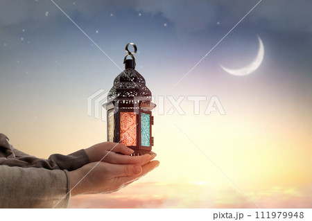 Ornamental Arabic lantern with burning candle 111979948