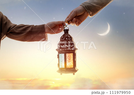 Ornamental Arabic lantern with burning candle Ornamental Arabic lantern with burning candle 111979950