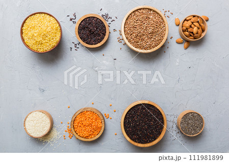 Various superfoods in smal bowl on colored background. Superfood as rice, chia, quinoa, lentils, nuts, sesame seeds, almonds. top view copy space 111981899