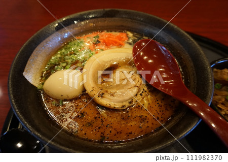 Ramen Japanese noodle dish served in a broth with sliced pork, green onion, boiled egg 111982370