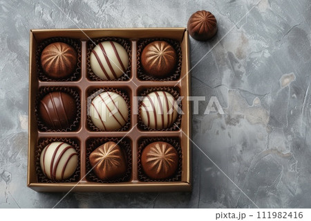 several chocolates in a box on a white surface 111982416