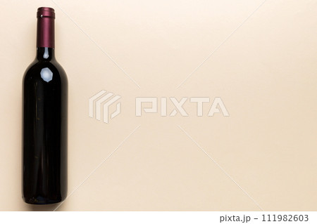 One Bottle of red wine on colored table. Flat lay, top view wth copy space One Bottle of red wine on colored table. Flat lay, top view wth copy space 111982603