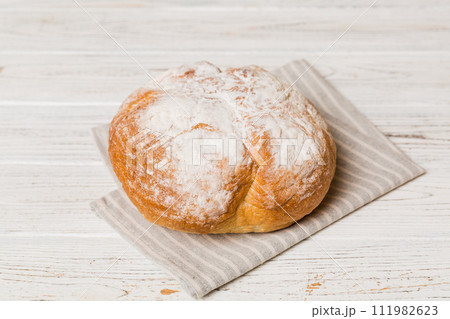 freshly baked bread with napkin on rustic table top view. Healthy white bread loaf isolated freshly baked bread with napkin on rustic table top view. Healthy white bread loaf isolated 111982623