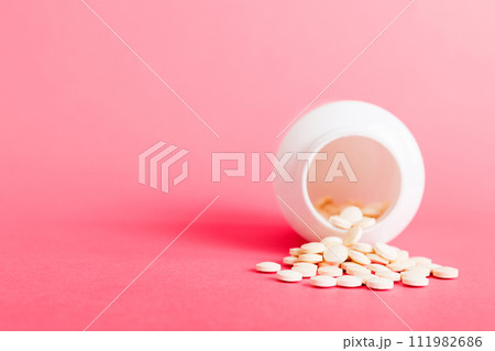 Medicine bottle and white pills spilled on a light background. Medicines and prescription pills flat lay background. White medical pills and tablets spilling out of a drug bottle Medicine bottle and white pills spilled on a light background. Medicines and prescription pills flat lay background. White medical pills and tablets spilling out of a drug bottle 111982686