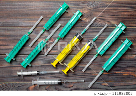 Top view of many syringes prepared for injection at wooden background. Treatment concept with copy space 111982803
