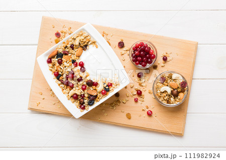 Healthy breakfast food with granola, yogurt, fruits and nuts. Dessert parfait with dried fruits for breakfast 111982924