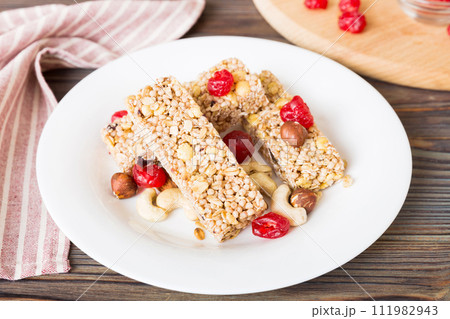 Various granola bars on table background. Cereal granola bars. Superfood breakfast bars with oats, nuts and berries, close up. Superfood concept Various granola bars on table background. Cereal granola bars. Superfood breakfast bars with oats, nuts and berries, close up. Superfood concept 111982943