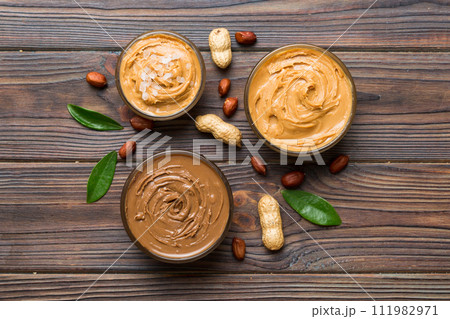 Glass jar with peanut butter on table background, top view space for text and close up Glass jar with peanut butter on table background, top view space for text and close up 111982971