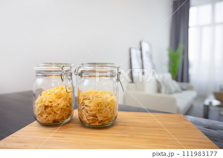 Jars of pasta on the background of the apartment. Jars of pasta on the background of the apartment. 111983177