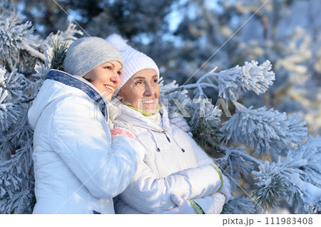 Happy women in winter clothes posing outdoors Happy women in winter clothes posing outdoors 111983408