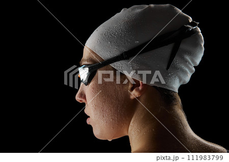Close up. rear view portrait of young athletic woman with waterdrops on face after swimming race against black studio background. 111983799