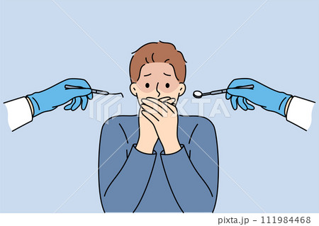 Man suffering from dentophobia closes mouth and stands near hands with dental devices 111984468