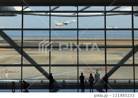羽田空港第2ターミナル国際線ロビー　飛行機を眺める女性　男女 111985233