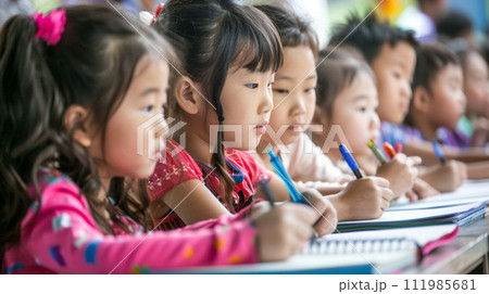 Group of happy asian kids students sitting in classroom and writing in notebooks 111985681