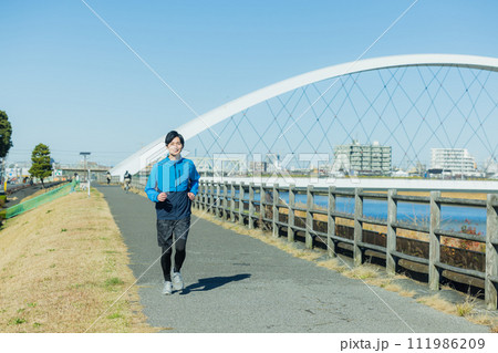 河川敷をランニングする若い男性 河川敷をランニングする若い男性 111986209