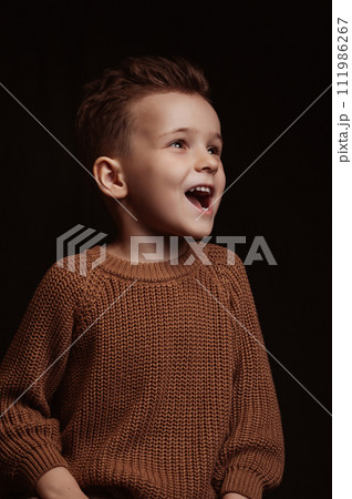 portrait of a happy screaming stylish white Caucasian child preschooler kid boy on chair 111986267