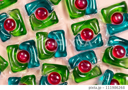 Laundry capsules on beige background close-up 111986268