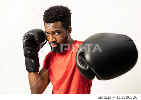 Confident African American Man with Boxing Gloves Ready to Fight Confident African American Man with Boxing Gloves Ready to Fight 111986526