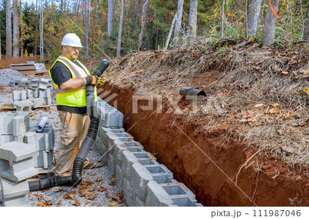 Process of laying drainage pipe for rainwater in retaining wall to prevent water buildup. 111987046