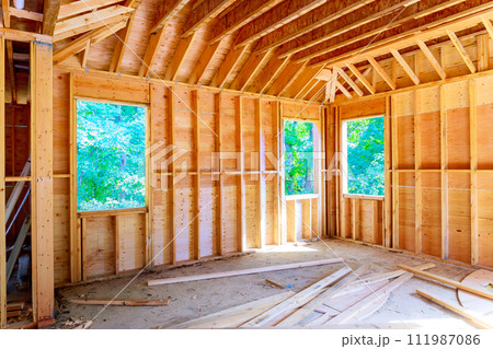 Unfinished space interior new house under construction with wooden framing beams Unfinished space interior new house under construction with wooden framing beams 111987086