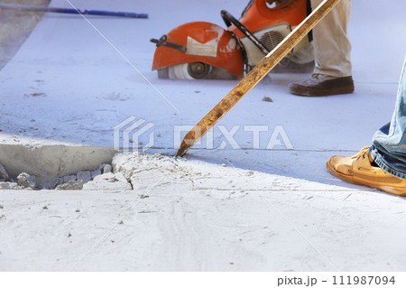 Wielding worker demolishes concrete old driveway at construction site Wielding worker demolishes concrete old driveway at construction site 111987094