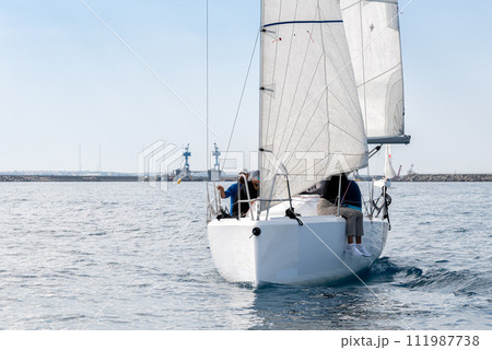 Racing yacht with white sails in a calm sea Racing yacht with white sails in a calm sea 111987738