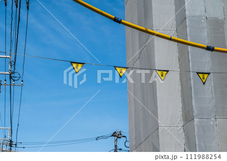 建設現場の三角旗と電線防護管 111988254