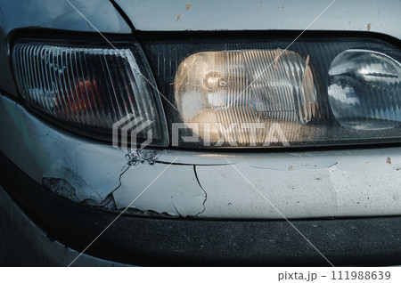 old car after an accident with damaged crumpled bumper close-up 111988639