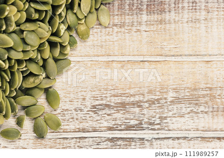 peeled pumpkin seeds on a wooden background 111989257