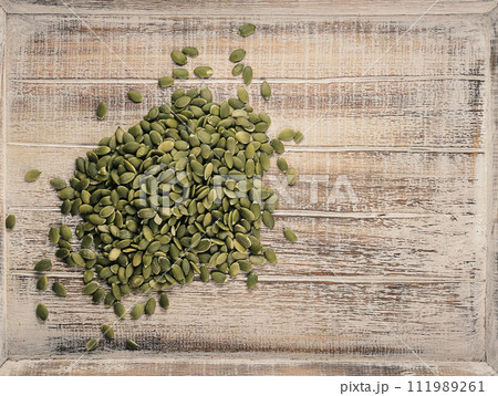 peeled pumpkin seeds on a wooden background peeled pumpkin seeds on a wooden background 111989261